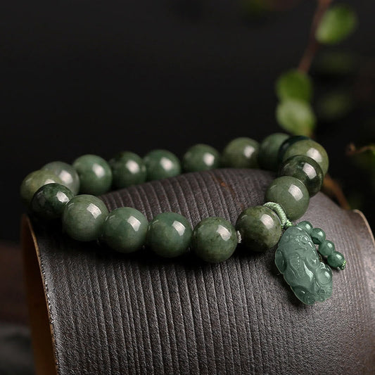Tibetan Jade PiXiu Prosperity Bracelet – Green jade bracelet with PiXiu on curved wood surface, prosperity gift