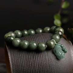 Tibetan Jade PiXiu Prosperity Bracelet – Green jade bracelet with PiXiu on curved wood surface, prosperity gift