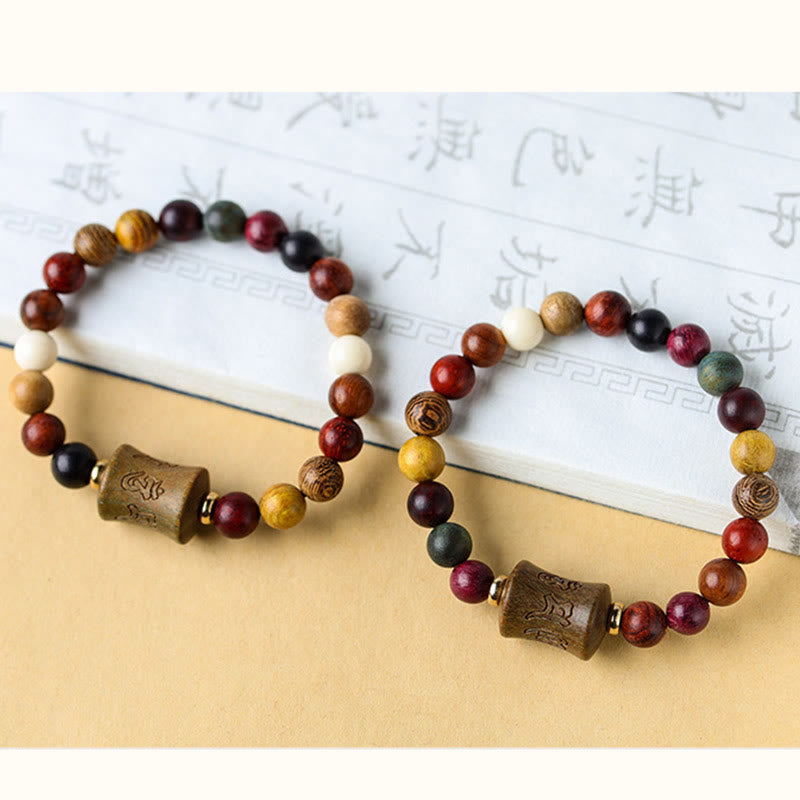 Multicolored Sandalwood Prayer Bracelet – Pair displayed on calligraphy book, paired prayer bracelets