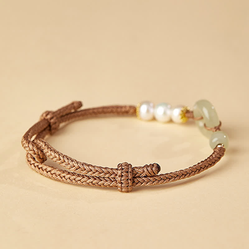 Hetian Jade Pearl Peace Buckle Bracelet – brown braided cord with jade beads white pearls and gold spacers, beige studio three-quarter view