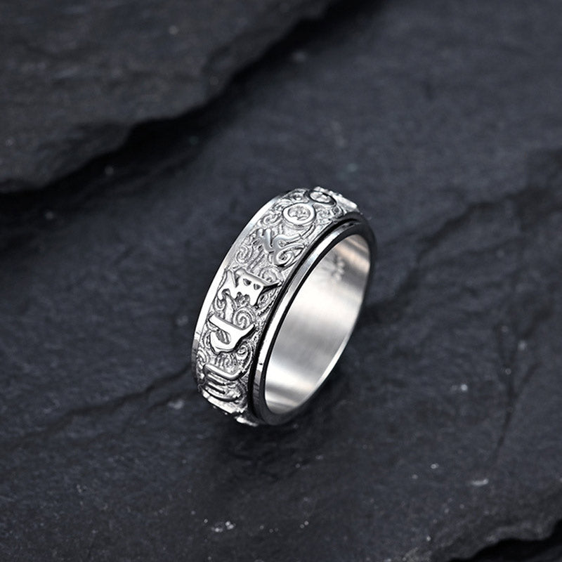 Om Mani Padme Hum Ring – Silver band with Nordic rune engravings on dark slate, meditation spinner