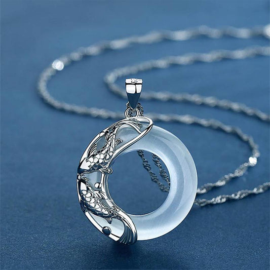 Sterling silver koi fish pendant necklace with white jade circle, yin-yang design on delicate twisted rope chain, blue background