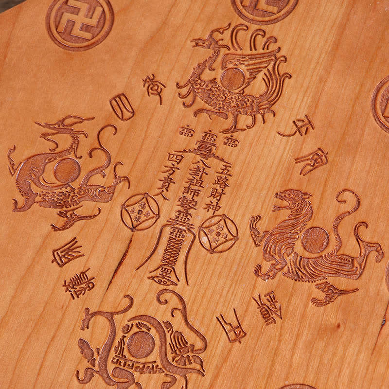 Peach Wood Bagua Map - single 13cm bagua mirror with red tassels and five coins on dark wood surface