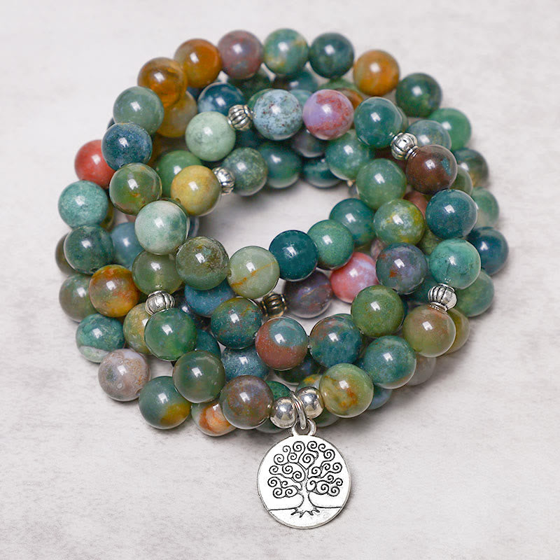 108 Mala Indian Agate Bracelet – stacked spiral agate beads with Tree of Life pendant on textured off-white surface