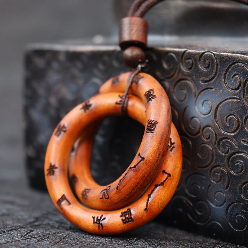 Qiankun Circle Necklace – Interlocked amber-toned wooden rings with burned Chinese calligraphy and constellation symbols on b