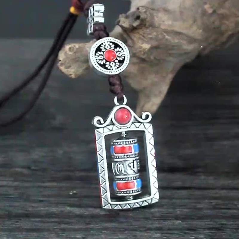 Om Mani Padme Hum Prayer Wheel Keychain – Low angle on weathered wood, red stone and turquoise accents, mantra keychain