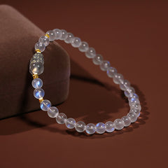 Moonstone PiXiu Bracelet – Moonstone beads draped over velvet cushion at angle, calming crystal bracelet
