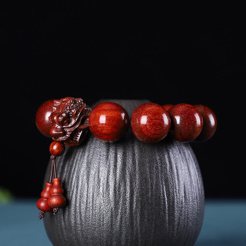 Multi-Wood Dragon Bracelet - Hand-carved lion head bead with double gourd charm on dark stand, Protection
