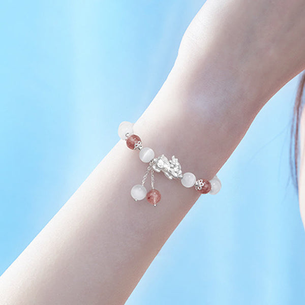 Cat's Eye PiXiu Bracelet – Wrist against blue sky background, airy outdoor jewelry photography