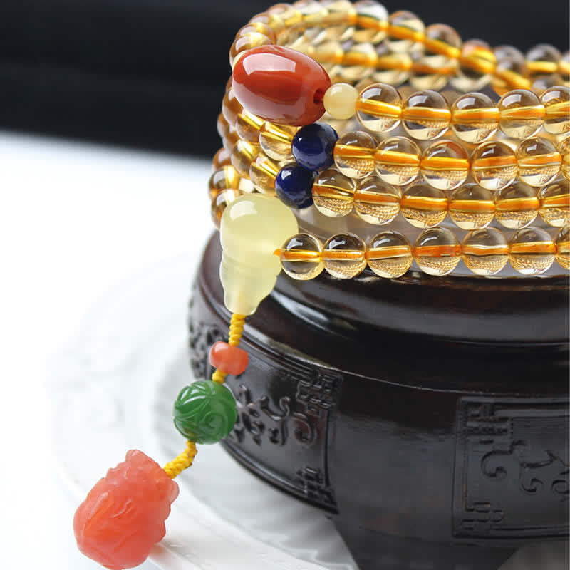 Citrine Mala Bracelet – Close-up of citrine mala on wooden stand with green jade charm detail