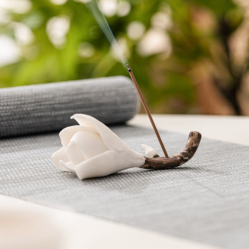 Gardenia Ceramic Incense Burner – White flower incense holder with smoke curling above, gray mat and greenery