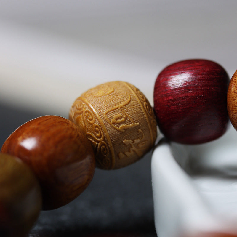 Tibetan Wood Bracelet – carved sandalwood bead with relief patterns amid burgundy tones, artisan bead bracelet