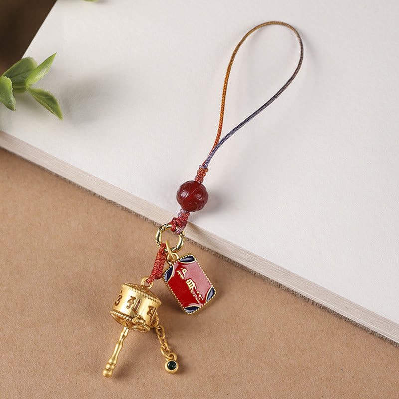 Prayer Wheel Phone Charm – Charm with red amulet plaque on kraft paper, protective talisman