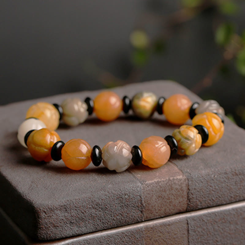 Golden Silk Jade Lotus Bracelet – Honey and peach lotus carved beads with black spacers on stone blocks, jade lotus