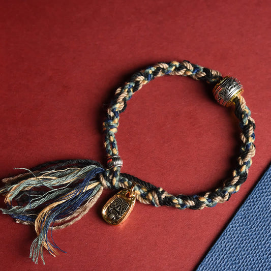 Zakiram Goddess Bracelet – Braided cord with tassel closure on split-tone background, adjustable handmade bracelet