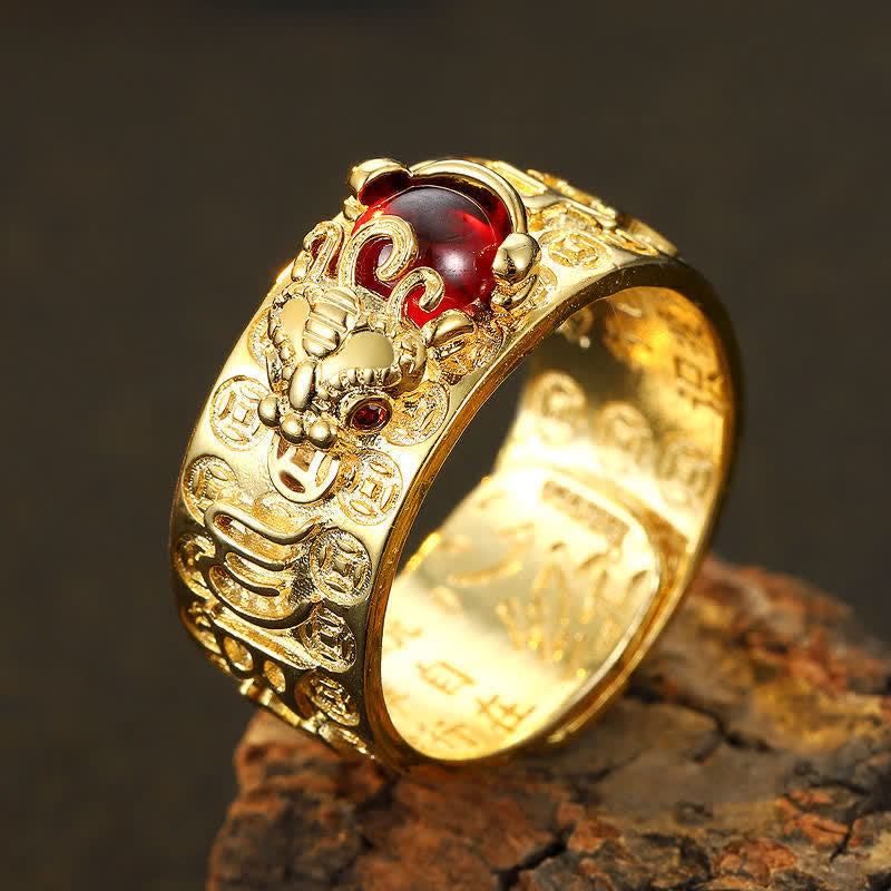PiXiu Garnet Heart Sutra Ring – Silver ring with Chinese guardian lion foo dog relief, oval red gemstone and ruby eye accents on dark stone, three-quarter low angle