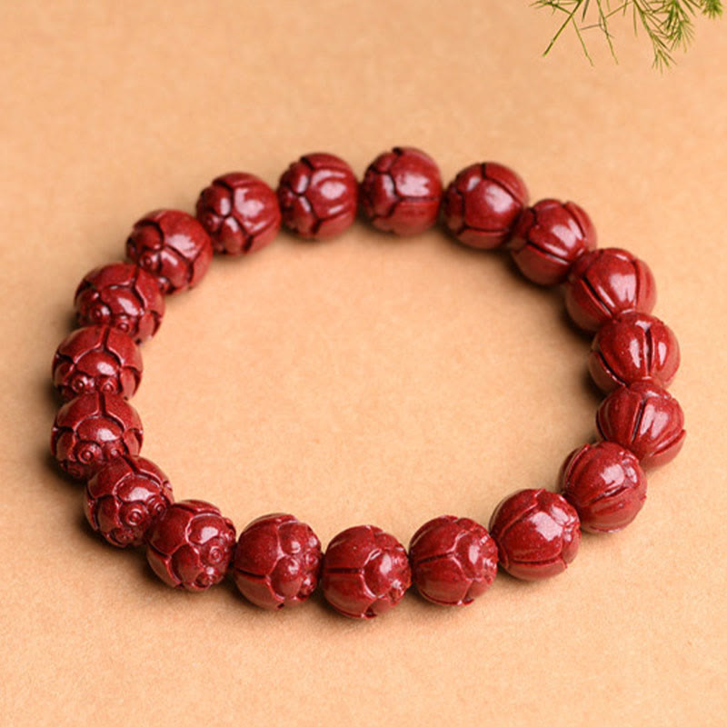 Cinnabar Om Mani Padme Hum Bracelet – lotus carved vermilion beads angled overhead, carved cinnabar jewelry