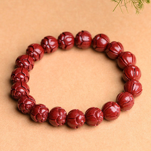 Cinnabar Om Mani Padme Hum Bracelet – lotus carved vermilion beads angled overhead, carved cinnabar jewelry