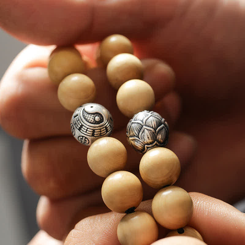 Peach Wood Yin Yang Bracelet – Yin yang and lotus carved metal beads cupped in palms, mindful jewelry