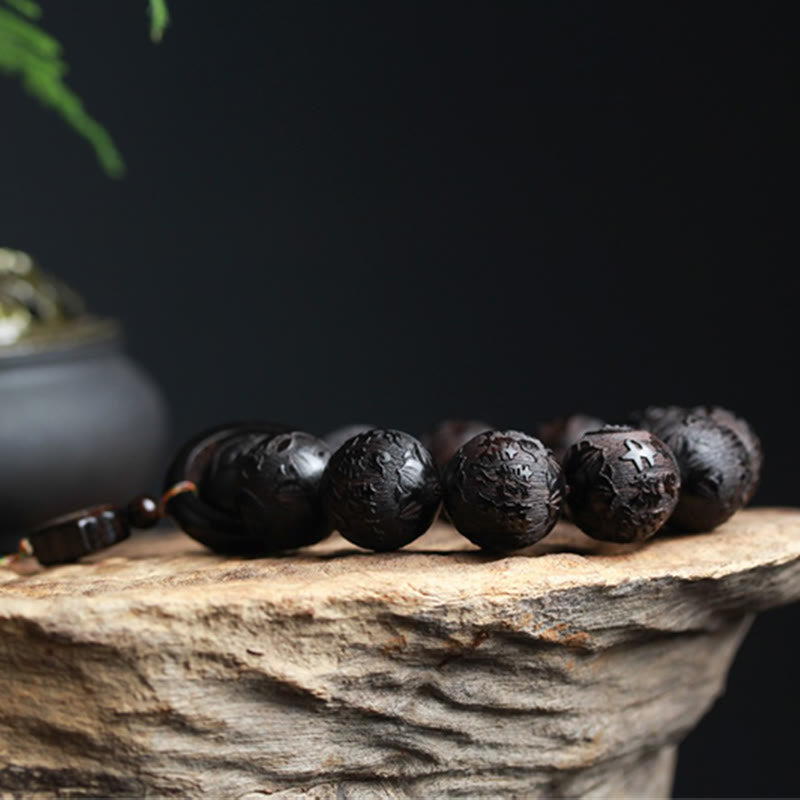 Ebony Wood Yin Yang Gourd Balance Bracelet - beads on weathered wood stump with dark ceramic pot, carved ebony bead bracelet