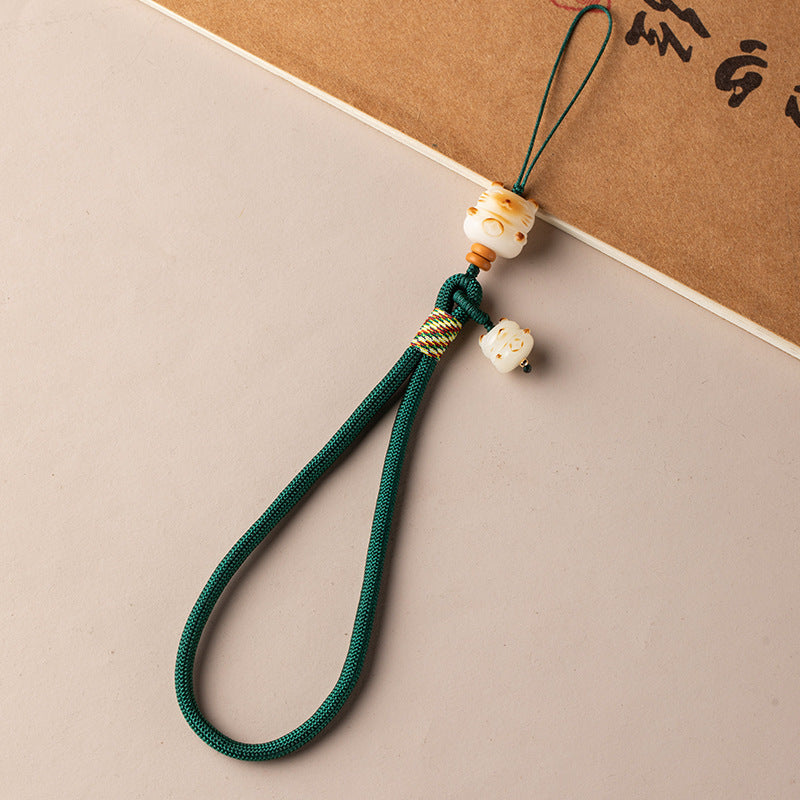 Bodhi Maneki Neko phone strap in dark green cord with lucky cat bodhi bead detail