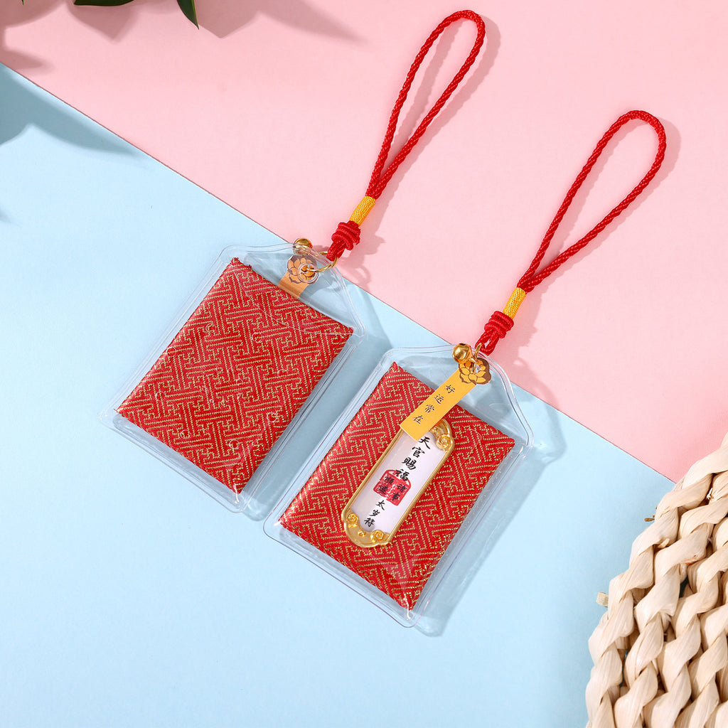 Two red Taisui protection amulets on pink and blue background