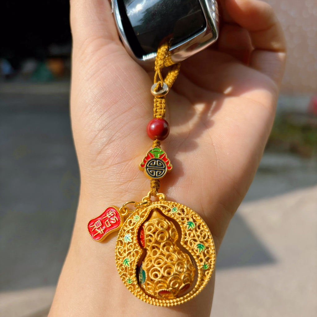 Gold enamel calabash keychain with fortune plaque on red background with Chinese text