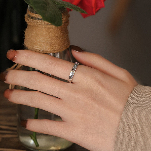 925 Sterling Silver Om Mani Padme Hum Ring – textured silver band worn with rose and jute vase, stacking ring lifestyle