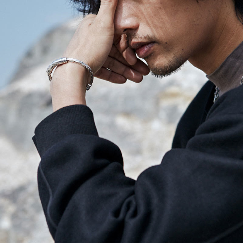 Tibetan Om Mani Padme Hum Engraved Copper Cuff Bangle – Side profile with contemplative pose, mountain backdrop, copper bracelet