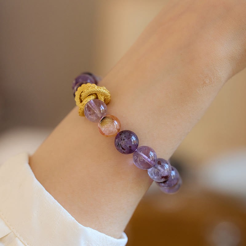 Purple Phantom Quartz Dragon Bracelet – Worn on wrist over cream blouse showing translucent purple beads, elegant