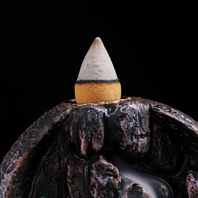 Resin Backflow Incense Burner – Lit incense cone on dark stone with thin descending smoke stream, aromatherapy