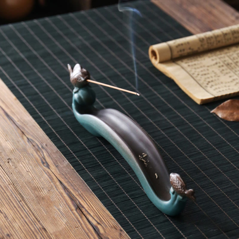 Double Koi Fish Mountain Incense Burner - teal koi wave holder with lit incense on green bamboo mat