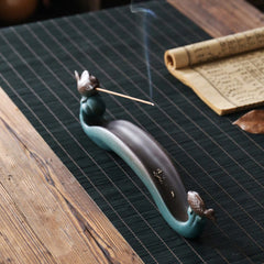 Double Koi Fish Mountain Incense Burner - teal koi wave holder with lit incense on green bamboo mat