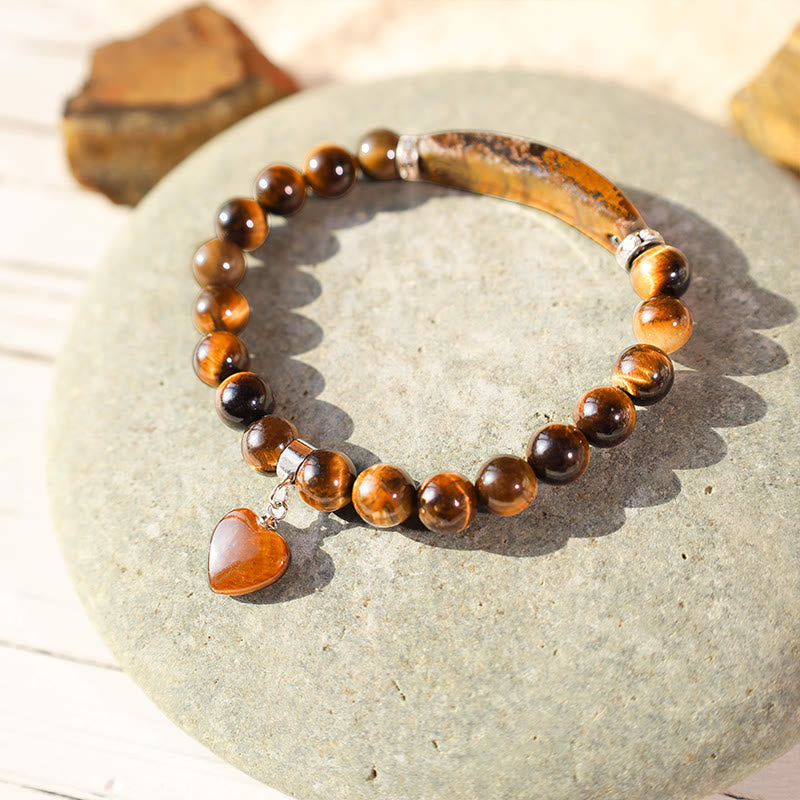 Natural Multi-Stone Love Heart Healing Bracelet - Golden tiger eye variant with chatoyant amber-brown beads, curved bar, and heart-shaped pendant on gray stone