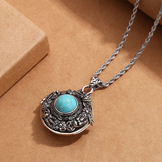 Tibetan Pi Xiu Necklace – Ornate silver locket with turquoise stone on brown paper