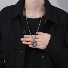Tibetan Copper Dragon Necklace - Worn on model, hand presenting dragon with blue eye, Masculine
