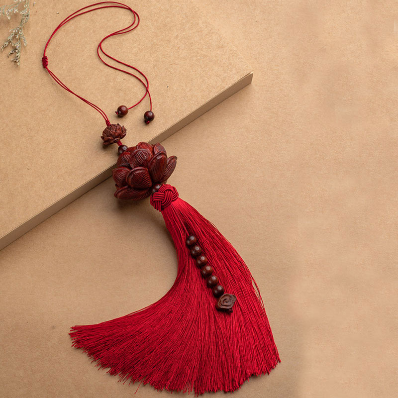 Red Sandalwood Lotus Tassel - red tassel on kraft paper with book prop, endless knot
