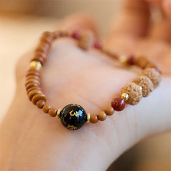 Bodhi Seed Bracelet – Close-up on wrist highlighting inscribed black bead and gold details, mens bracelet