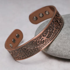Solid copper cuff bracelet featuring hand-engraved tree of life with Celtic triquetra knots and six magnetic inlays at terminals on gray river stone