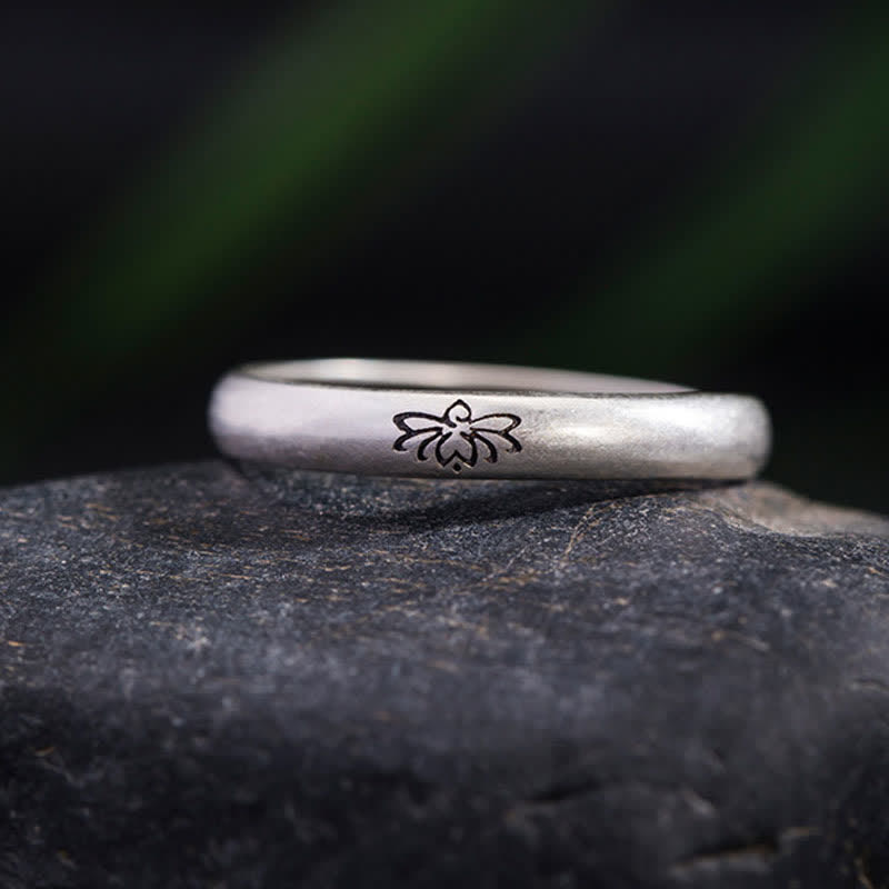 Lotus Enlightenment Ring - lotus engraving detail on natural stone with green blur, oxidized