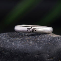 Lotus Enlightenment Ring - lotus engraving detail on natural stone with green blur, oxidized