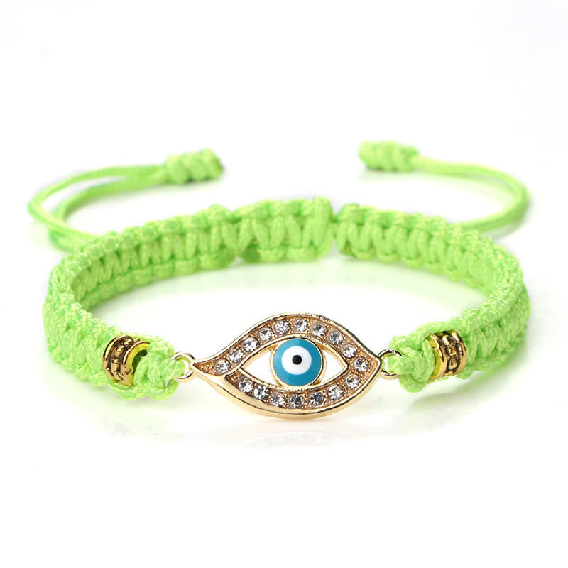 Lime green cord evil eye bracelet with gold blue evil eye crystal charm on white bg