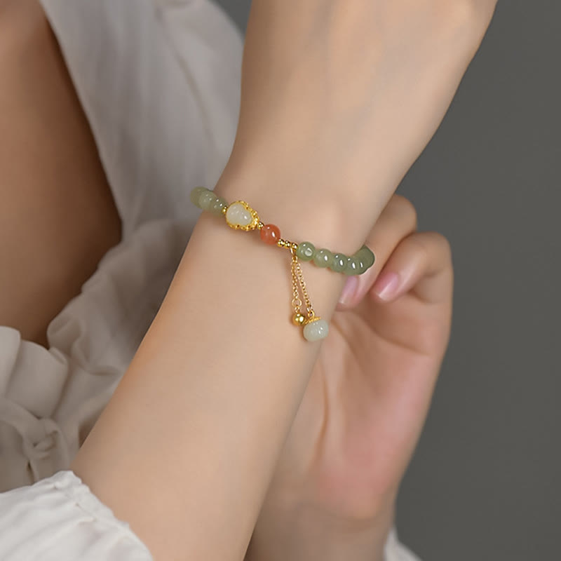 Hetian Jade Gourd Lotus Bracelet worn on wrist with flowing white fabric, lifestyle elegance, feminine charm