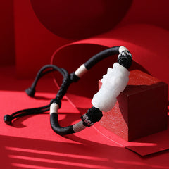 Natural Jade PiXiu Bracelet – side view on red wood block, silver wrap accents, black cord, jade luck
