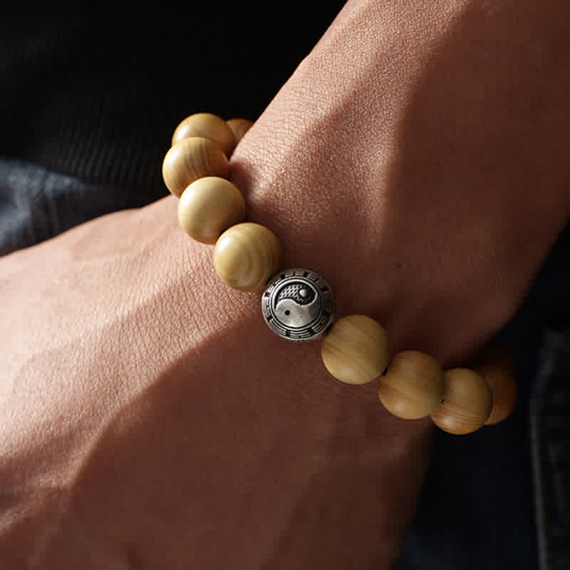 Peach Wood Yin Yang Bracelet – Worn on wrist showing yin yang bagua metal bead, harmony jewelry