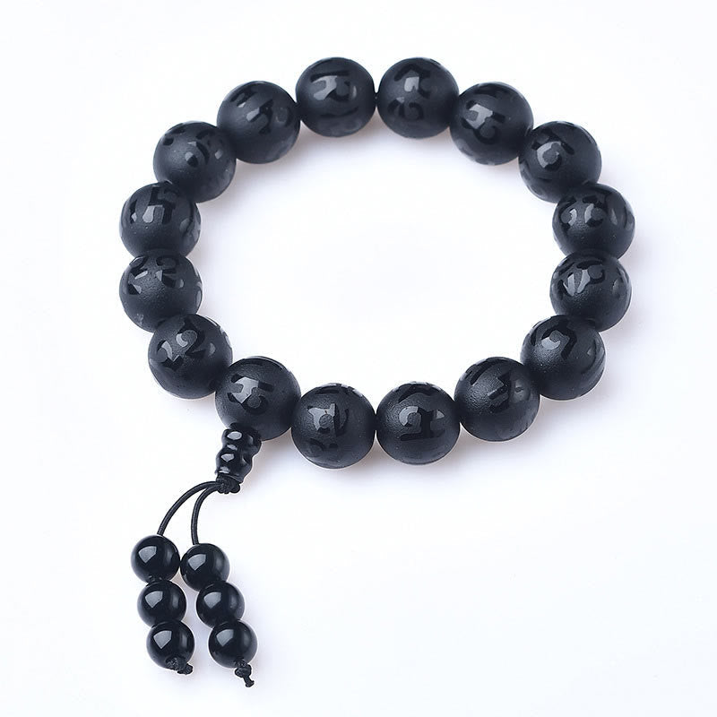 Black Onyx Mantra Bracelet – Glossy polished black beads on white background, top-down view
