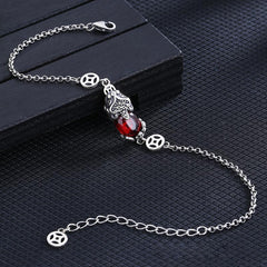 Copper Garnet PiXiu Wealth Bracelet – Silver chain with red garnet PiXiu on dark wood block, angled shot