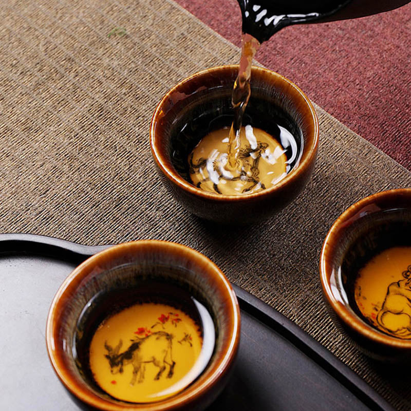 12 Zodiac Jian Zhan Teacup - four cups overhead showing Dragon Snake Horse Goat zodiac ink paintings on cream medallion bases