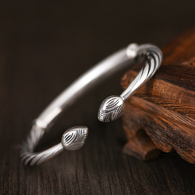 Tibetan Heart Sutra Cuff Bracelet – elevated view on fine wood grain, twisted wire texture and central engraved plate