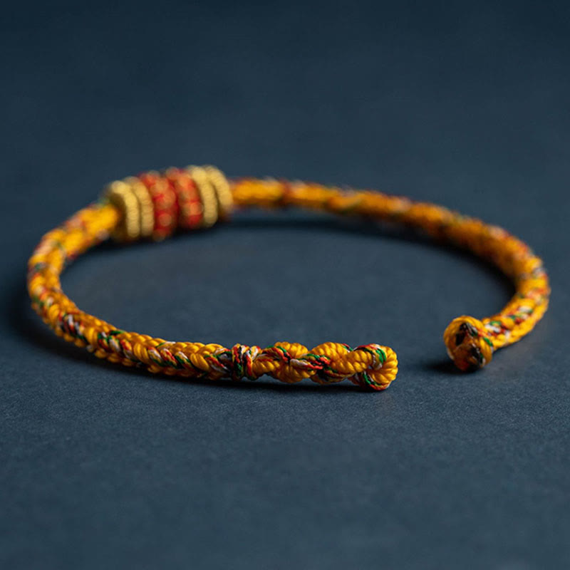 Handmade braided yellow cord bracelet with natural wood disc beads and multicolor threads, adjustable knot closure, bohemian ethnic friendship jewelry